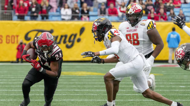 Dec 30, 2022; Charlotte, NC, USA; North Carolina State Wolfpack running back Michael Allen (24) tries to keep his balance running after the catch as Maryland Terrapins defensive back Deonte Banks (3) comes in to attempt the stop during the first half in the 2022 Duke's Mayo Bowl at Bank of America Stadium.